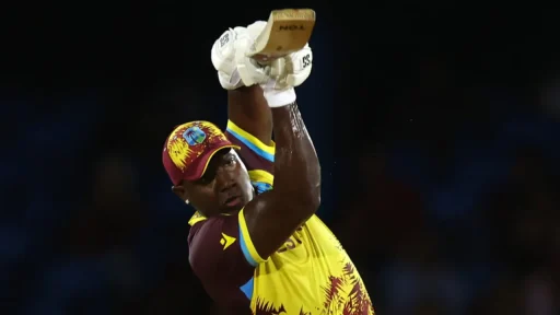 Cricketer playing shot during nighttime match.