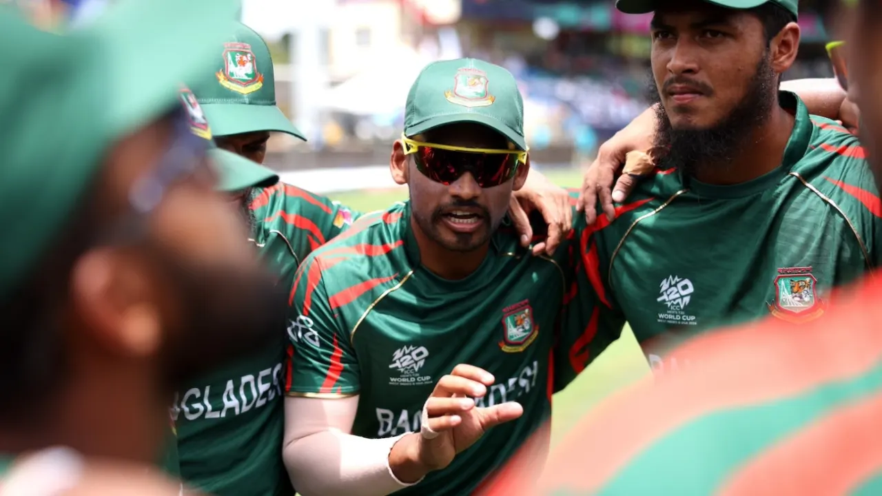 Bangladesh cricket players strategizing during outdoor team huddle.