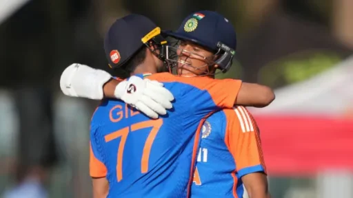 Two cricketers embrace warmly during a match.