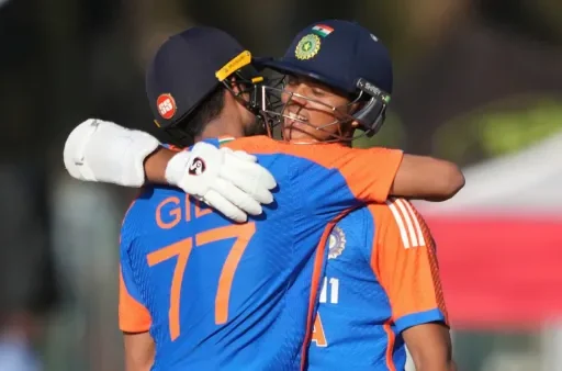Two cricketers embrace warmly during a match.