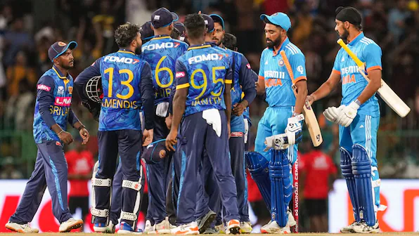 Cricketers from two teams discussing on the field.