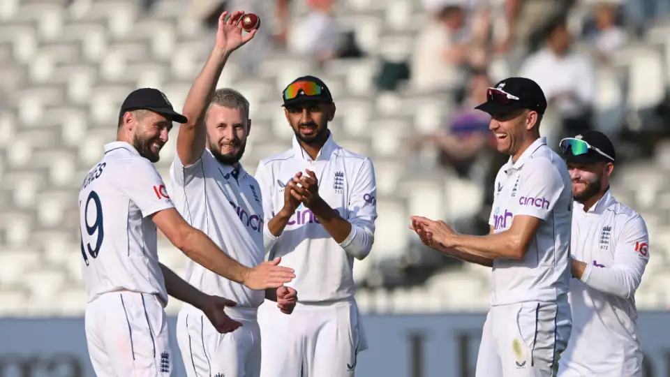 Cricketers celebrating a bowler's achievement on field