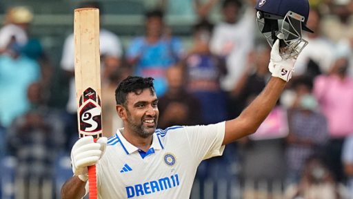 Cricket player celebrating with bat raised at stadium