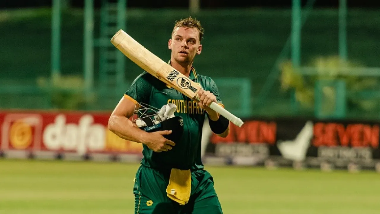 Cricketer holding bat in stadium after game