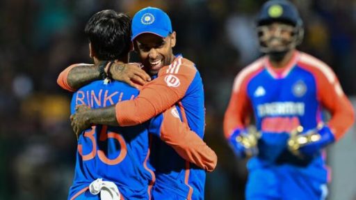 Two cricketers celebrating victory with a hug on field