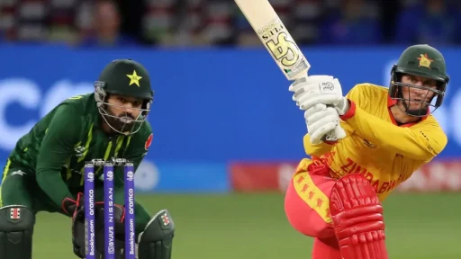 Cricketer striking ball, wicketkeeper ready behind stumps.