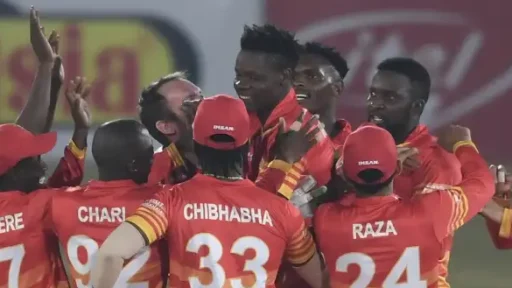 Cricket team celebrating victory on field at night