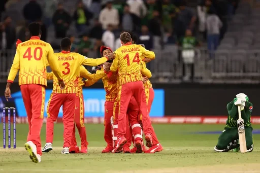 Cricket team celebrates victory while opponent kneels disappointed