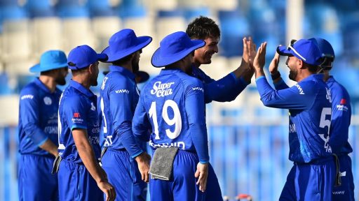 Cricket team in blue celebrates on field