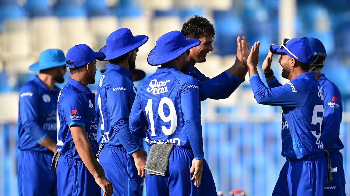 Cricket team in blue celebrates on field