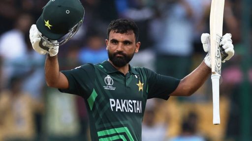 Pakistani cricketer raising helmet and bat in celebration