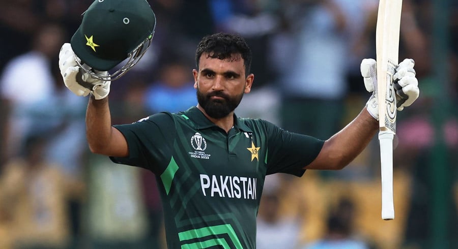 Pakistani cricketer raising helmet and bat in celebration