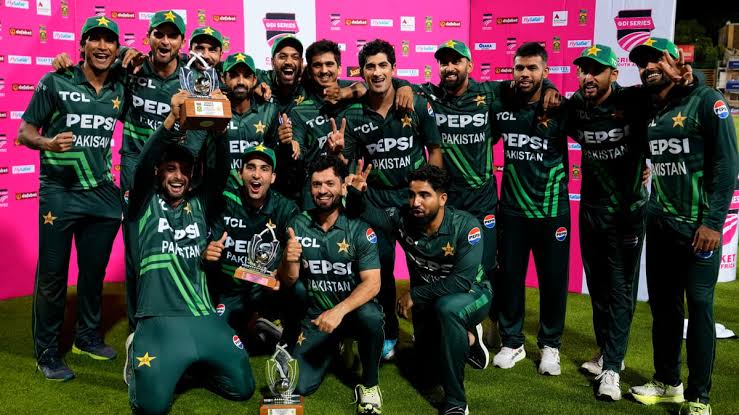 Pakistani cricket team celebrating with trophy at night