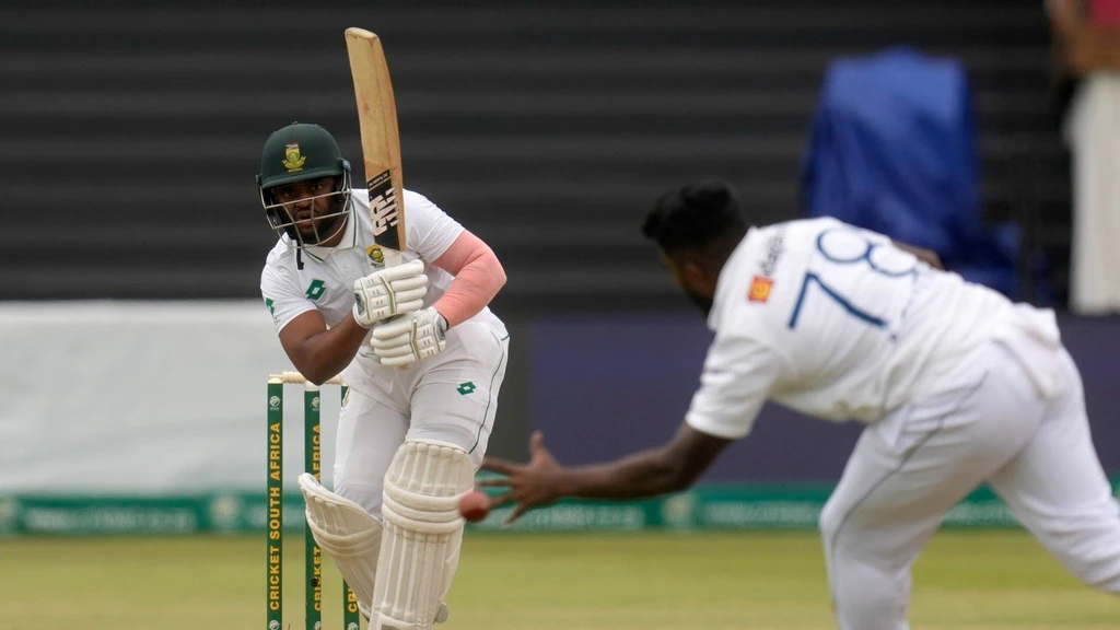 Batsman plays shot in cricket match against bowler