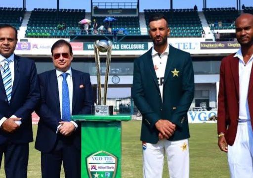 Cricket officials and players with trophy on field