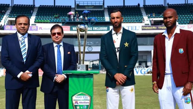 Cricket officials and players with trophy on field