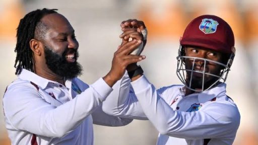 Cricket players celebrate with the ball on field