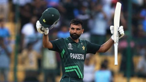 Pakistani cricketer celebrating century with raised bat