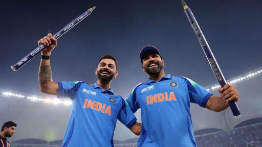 Two Indian cricketers celebrating with oversized pencils