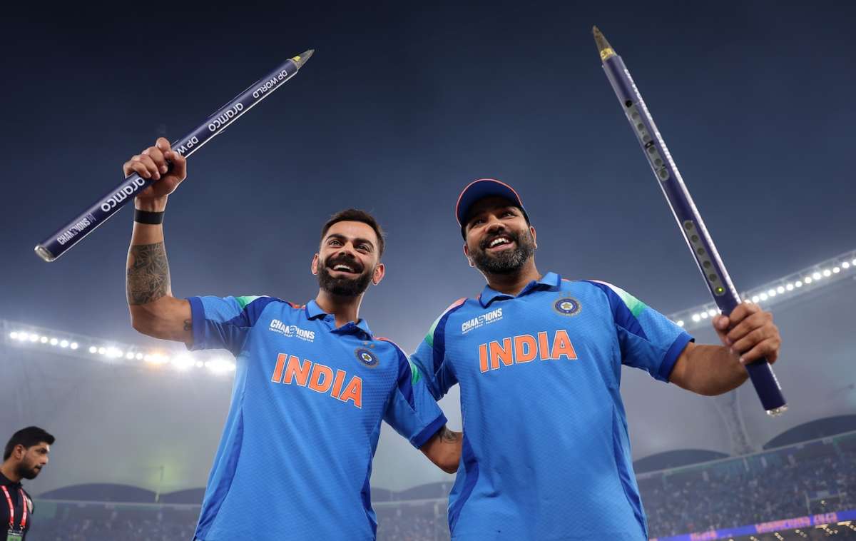 Two Indian cricketers celebrating with oversized pencils