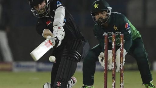 Cricket batsman playing a shot during a night match