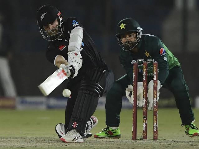 Cricket batsman playing a shot during a night match